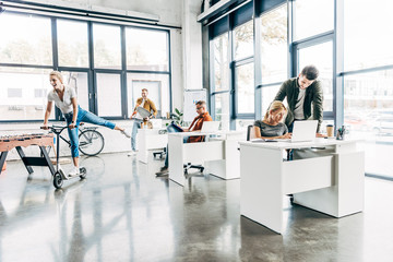 Wall Mural - Group of happy progressive entrepreneurs working on startup together at modern open space office