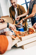 © LIGHTFIELD STUDIOS - cropped shot of group of entrepreneurs having pizza for lunch together while working on startup at office