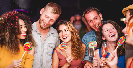 Young people dancing and drinking champagne at confetti party night