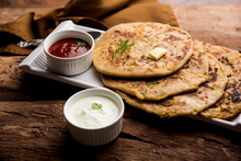 Aloo Paratha / Indian Potato Stuffed Flatbread. Served With Fresh Curd And Tomato Ketchup. Selective Focus