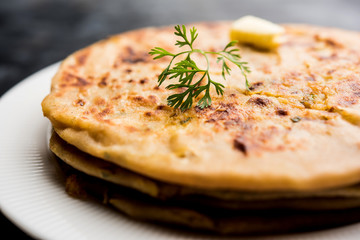 Aloo Paratha / Indian Potato stuffed Flatbread. Served with fresh curd and tomato ketchup. selective focus