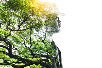 double exposure image of the engineer thinking during sunrise overlay with forest image and white copy space. the concept of clean energy, futuristic, industrial4.0 and hydroelectric.