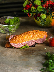 sandwich with bread rolls, lettuce, sausage ham on wooden background. Picnic food. top view