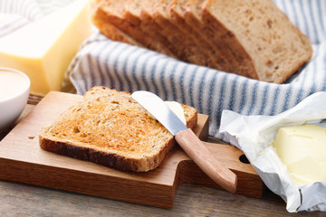 Toast bread slices, butter, and cheese for breakfast.