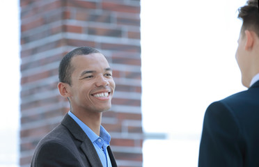 smiling young businessman on background of office.