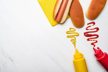 Wall Mural - top view of tasty hot dog with mustard and ketchup on white marble surface