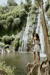 Wall Mural - stylish young woman taking picture for social media in waterfall