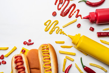 Sticker - top view of tasty hot dogs and fries with mustard and ketchup on white surface