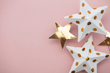 Wall Mural - White and gold star decorations on a pastel pink. Seasonal festive background