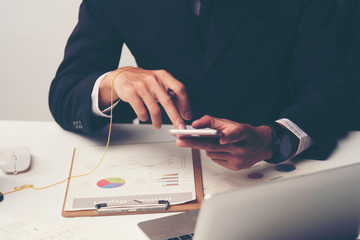 Side view shot of a man's hands using smart phone in interior, rear view of business man hands busy using cell phone, young male student typing on phone sitting at wooden table focus on the hand