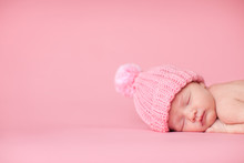 Newborn Baby Girl In Knit Hat, Isolated On Pink, Room For Text