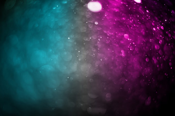 Bokeh of water spray and light leak on two tone background.