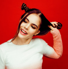 young pretty teenage girl on bright red background, happy smilin