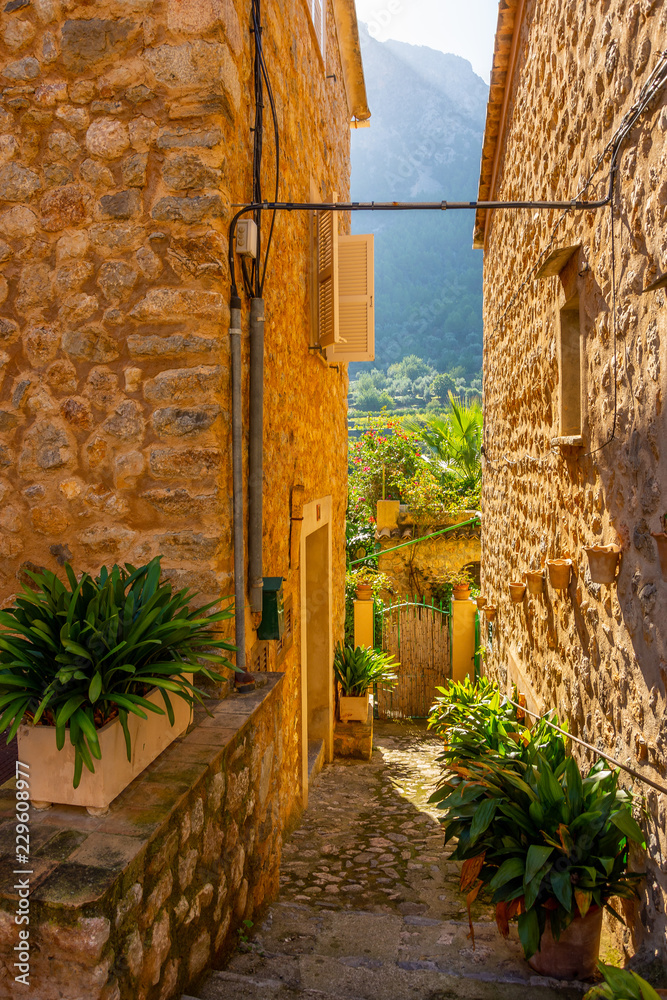 Kopfsteinpflaster-Gasse mit Natursteinhäusern auf Mallorca