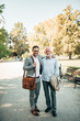 © bnenin - Elegant father and son in the park. Portrait of senior and young man outdoors. Looking at camera.