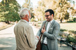 © bnenin - Family meeting in a park. Senior man and elegant young man meet in the park.