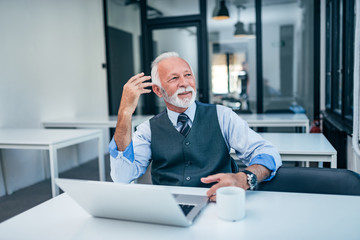 Wall Mural - Senior businessman daydreaming at modern office.