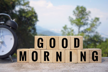 Wall Mural - Motivational and inspirational quote - ‘GOOD MORNING’ written on wooden blocks. Blurred styled background.