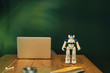 © Westend61 - Toy robot and laptop on work table