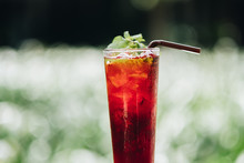 Refreshing Lemon And Mint Ice Tea Served Outdoors. Blur Garden Background