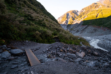 Poster - Trail walkway with rocks and river from a glacier. Track: Fox Glacier, New Zealand.