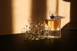 © Pixel-Shot - Transparent bottle of perfume with beautiful flowers on dark table