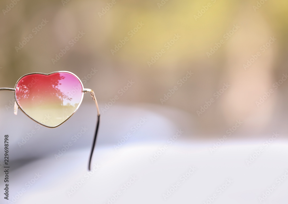 Heart shaped sunglasses on blurred background