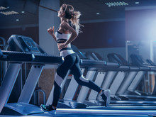 Woman Trains On A Treadmill In The Gym. Young Fitness Girl Running On Treadmill Machine. Sports Exercises For Weight Loss.