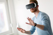 © NDABCREATIVITY - Man wearing virtual reality headset at home