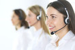 © rogerphoto - Group of call center operators at work. Focus on beautiful business woman in headset