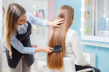 Poster - Master hairdresser woman combing hair of client in chair beauty salon spa