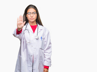 Wall Mural - Young arab doctor woman over isolated background doing stop sing with palm of the hand. Warning expression with negative and serious gesture on the face.