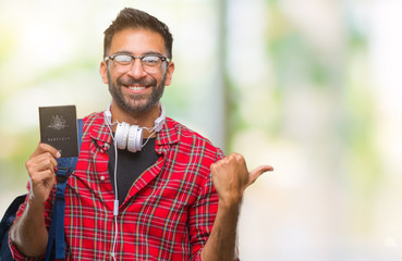 Sticker - Adult hispanic student man holding passport of australia over isolated background pointing and showing with thumb up to the side with happy face smiling