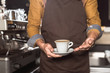 © LIGHTFIELD STUDIOS - cropped shot of barista in apron holding cup of fresh made coffee