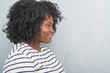 © Krakenimages.com - Young african american plus size woman over grey grunge wall looking to side, relax profile pose with natural face with confident smile.