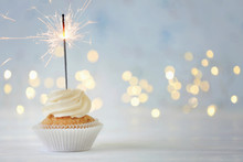 Delicious Cupcake With Sparkler On White Table Against Blurred Lights