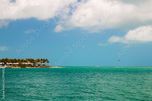 Turquoise Blue Sea Horizon And Island With Sandy Beach Palm Trees