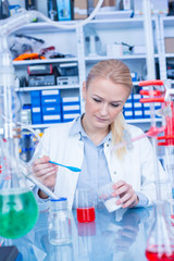 Sticker - Female laboratory assistant with chemical experiment in scientific laboratory. Female medical or scientific researcher using test tube on laboratory.