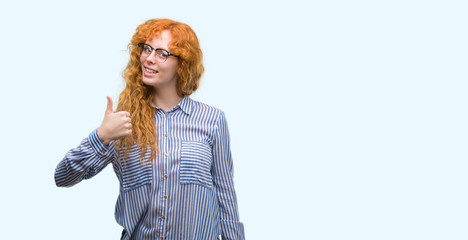 Poster - Young redhead bussines woman doing happy thumbs up gesture with hand. Approving expression looking at the camera with showing success.