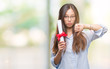 © Krakenimages.com - Young asian woman holding degree over isolated background with angry face, negative sign showing dislike with thumbs down, rejection concept