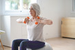 © goodluz - Attractive elderly woman exercising at home with swiss ball