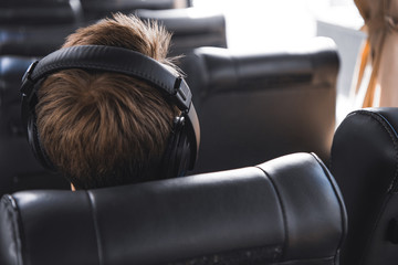 rear view of male tourist in headphones listening music during trip on travel bus