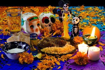 ofrenda de día de muertos. con calavera de azúcar, pan de muerto y platillo tradicional mexicano 2