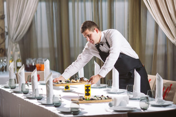 Wall Mural - Waiter serving table in the restaurant preparing to receive guests.