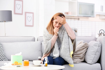 Wall Mural - Woman suffering from cough and headache on sofa at home