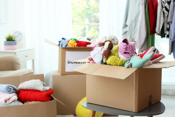 Wall Mural - Donation box with clothes and toys on table indoors. Space for text