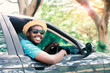African man driver Wearing sunglasses and smiling while sitting in a car with open front window.