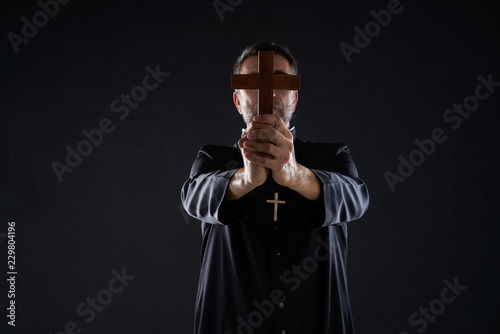 Fotomural Priest holding cross of wood praying