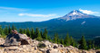 Hiker reclines on a stone bench overlooking Mount Hood in the distance