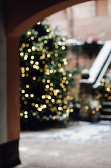 Wall Mural - Blurry, golden, illuminated Christmas fairy lights on outdoor xmas tree at the Nuremberg Christkindles market in winter creating a beautiful out of focus bokeh effekt.